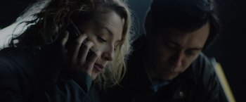 Movie still from “Troll” (2022), directed by Roar Uthaug – A woman is talking on a cell phone while a man looks on; Close Up shot, Low angle
