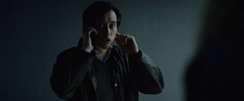 Movie still from “Troll” (2022), directed by Roar Uthaug – A man talking on a cell phone while wearing a jacket; Close Up shot, Low angle