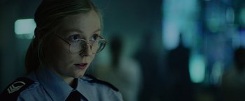 Movie still from “Troll” (2022), directed by Roar Uthaug – A young woman wearing glasses and a police uniform; Close Up shot, Over the shoulder angle