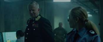 Movie still from “Troll” (2022), directed by Roar Uthaug – A man in a military uniform standing next to another man; Medium shot, Over the shoulder angle