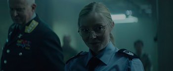 Movie still from “Troll” (2022), directed by Roar Uthaug – A woman in a police uniform with glasses; Close Up shot, Over the shoulder angle