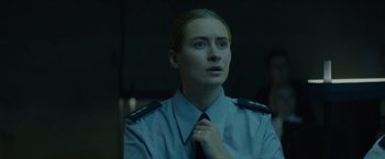 Movie still from “Troll” (2022), directed by Roar Uthaug – A woman in a uniform is adjusting her tie; Close Up shot, Low angle