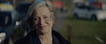 Movie still from “Troll” (2022), directed by Roar Uthaug – An older woman smiling for the camera; Close Up shot, Low angle