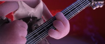 Movie still from “Trolls World Tour” (2020), directed by Walt Dohrn – A person holding an electric guitar; Close Up shot, Over the shoulder angle