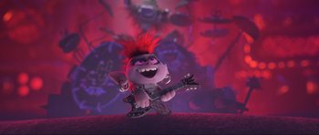 Movie still from “Trolls World Tour” (2020), directed by Walt Dohrn – A troll with red hair is playing a guitar; Wide shot, High angle