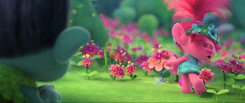 Movie still from “Trolls World Tour” (2020), directed by Walt Dohrn – Many pink flowers in the grass; Wide shot, Over the shoulder angle