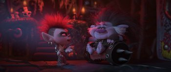 Movie still from “Trolls World Tour” (2020), directed by Walt Dohrn – A couple of trolls sitting next to each other on top of a table; Wide shot, Over the shoulder angle