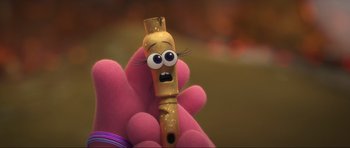 Movie still from “Trolls World Tour” (2020), directed by Walt Dohrn – A person holding up a toy flute with a face on it; Extreme Close Up shot, High angle