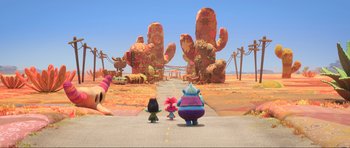 Movie still from “Trolls World Tour” (2020), directed by Walt Dohrn – A group of people walking down a road in the desert; Extreme Wide shot, High angle