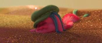 Movie still from “Trolls World Tour” (2020), directed by Walt Dohrn – A troll doll laying on the ground wearing a green hat; Close Up shot, High angle