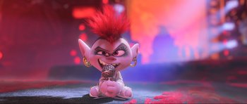 Movie still from “Trolls World Tour” (2020), directed by Walt Dohrn – A troll doll is holding a microphone in its mouth; Medium shot, High angle