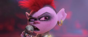 Movie still from “Trolls World Tour” (2020), directed by Walt Dohrn – An image of an animated character singing with a microphone; Close Up shot, Over the shoulder angle