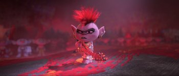 Movie still from “Trolls World Tour” (2020), directed by Walt Dohrn – A troll doll with a red mohawk is holding a guitar; Wide shot, High angle