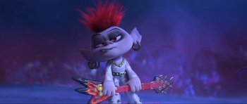 Movie still from “Trolls World Tour” (2020), directed by Walt Dohrn – A troll with red hair is holding a guitar; Medium shot, Low angle