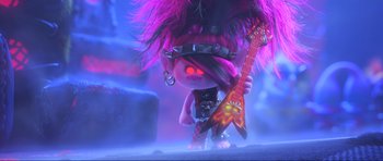 Movie still from “Trolls World Tour” (2020), directed by Walt Dohrn – A troll holding a red guitar in a purple room; Medium shot, Over the shoulder angle