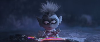 Movie still from “Trolls World Tour” (2020), directed by Walt Dohrn – A troll doll sitting on top of a pile of lights; Medium shot, High angle