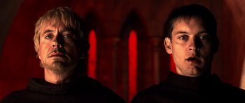 Movie still from “Tropic Thunder” (2008), directed by Ben Stiller – Two men are facing each other in front of a red background; Close Up shot, Low angle