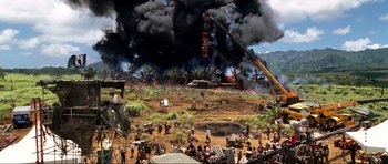 Movie still from “Tropic Thunder” (2008), directed by Ben Stiller – People are gathered in a field as a helicopter is on fire; Extreme Wide shot, High angle