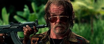 Movie still from “Tropic Thunder” (2008), directed by Ben Stiller – A person holding a gun; Close Up shot, Low angle