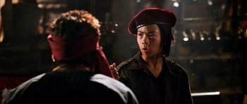 Movie still from “Tropic Thunder” (2008), directed by Ben Stiller – A man wearing a red hat and a black jacket; Close Up shot, Over the shoulder angle