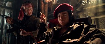 Movie still from “Tropic Thunder” (2008), directed by Ben Stiller – A man in a red hat is holding a cigarette; Medium shot, Low angle