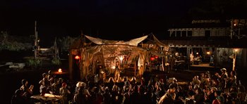 Movie still from “Tropic Thunder” (2008), directed by Ben Stiller – A group of people sitting in front of an outdoor stage; Extreme Wide shot, High angle