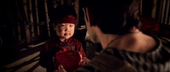 Movie still from “Tropic Thunder” (2008), directed by Ben Stiller – A little boy wearing a red hat and holding a red bag; Close Up shot, Over the shoulder angle
