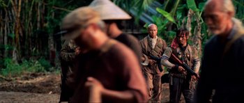Movie still from “Tropic Thunder” (2008), directed by Ben Stiller – A group of people standing next to each other on a field; Medium shot, Over the shoulder angle
