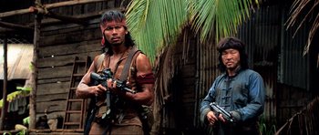 Movie still from “Tropic Thunder” (2008), directed by Ben Stiller – Two men in native american garb holding guns; Medium shot, Low angle