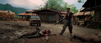 Movie still from “Tropic Thunder” (2008), directed by Ben Stiller – A man laying on the ground next to a dead body; Wide shot, Low angle