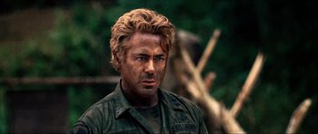 Movie still from “Tropic Thunder” (2008), directed by Ben Stiller – A person wearing a shirt and a jacket; Close Up shot, Over the shoulder angle