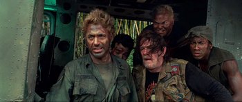 Movie still from “Tropic Thunder” (2008), directed by Ben Stiller – A group of men standing next to each other in the woods; Medium shot, Low angle