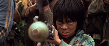 Movie still from “Tropic Thunder” (2008), directed by Ben Stiller – A young person holding a camera in front of a crowd of onlookers; Close Up shot, Low angle