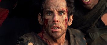 Movie still from “Tropic Thunder” (2008), directed by Ben Stiller – A person with blood all over his face; Close Up shot, Over the shoulder angle