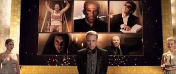 Movie still from “Tropic Thunder” (2008), directed by Ben Stiller – A man in a black jacket and several other men in a black suit; Medium shot, Low angle