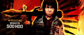 Movie still from “Tropic Thunder” (2008), directed by Ben Stiller – A painting of an asian boy holding a gun; Medium shot, Low angle