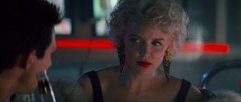 Movie still from “True Romance” (1993), directed by Tony Scott – A woman with blonde hair and red lipstick; Close Up shot, Over the shoulder angle