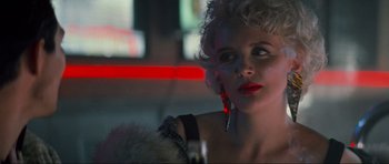 Movie still from “True Romance” (1993), directed by Tony Scott – A woman with red lipstick looking at the camera; Close Up shot, Over the shoulder angle