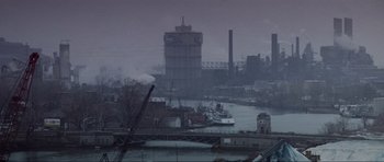 Movie still from “True Romance” (1993), directed by Tony Scott – A view of a river with a large clock tower in the background; Extreme Wide shot, High angle