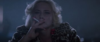 Movie still from “True Romance” (1993), directed by Tony Scott – A woman smoking a cigarette while wearing a leopard print jacket; Close Up shot, Low angle