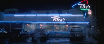 Movie still from “True Romance” (1993), directed by Tony Scott – A neon sign on the side of a building; Extreme Wide shot, Low angle