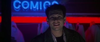 Movie still from “True Romance” (1993), directed by Tony Scott – A young man is smiling in front of a neon sign; Close Up shot, Low angle