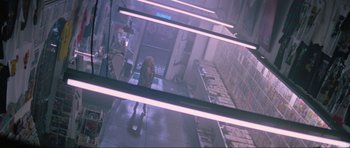 Movie still from “True Romance” (1993), directed by Tony Scott – A woman walking down a hallway in a building; Wide shot, Overhead angle