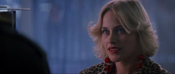 Movie still from “True Romance” (1993), directed by Tony Scott – A woman with blonde curly hair wearing a leopard print jacket; Close Up shot, Over the shoulder angle