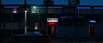 Movie still from “True Romance” (1993), directed by Tony Scott – A car parked in front of a motel entrance at night; Extreme Wide shot, Low angle