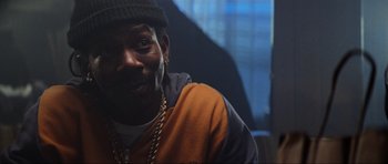 Movie still from “True Romance” (1993), directed by Tony Scott – A person wearing a hat and chains; Close Up shot, Low angle