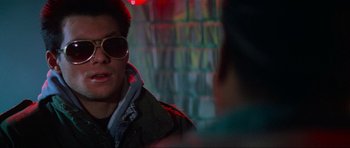 Movie still from “True Romance” (1993), directed by Tony Scott – A man wearing sunglasses talking to another man; Close Up shot, Over the shoulder angle