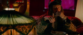 Movie still from “True Romance” (1993), directed by Tony Scott – A man with long dreadlocks eating food from chopsticks; Medium shot, Over the shoulder angle