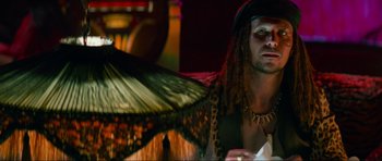 Movie still from “True Romance” (1993), directed by Tony Scott – A man with dreadlocks sitting in front of an umbrella; Close Up shot, Low angle