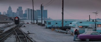Movie still from “True Romance” (1993), directed by Tony Scott – A row of blue trailers parked on the side of the road; Extreme Wide shot, High angle